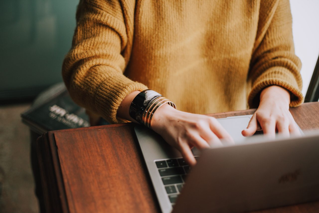 Computer user typing on Macbook