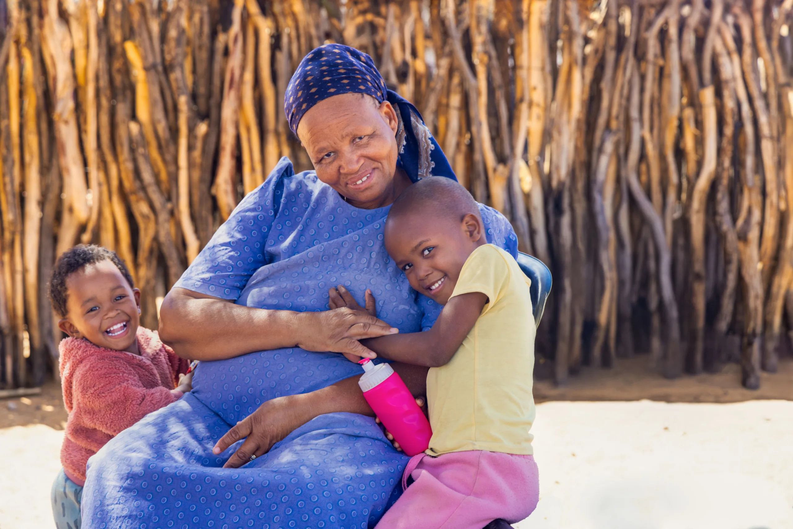 A grandmother hugging two little children