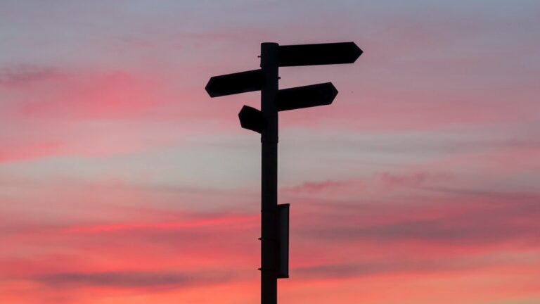 Silhouette of a direction sign during sunset