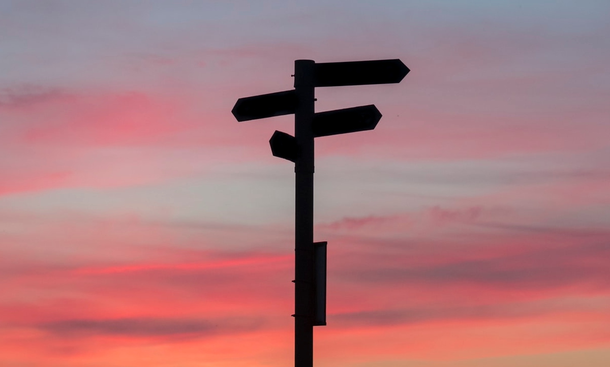 Silhouette of a direction sign during sunset