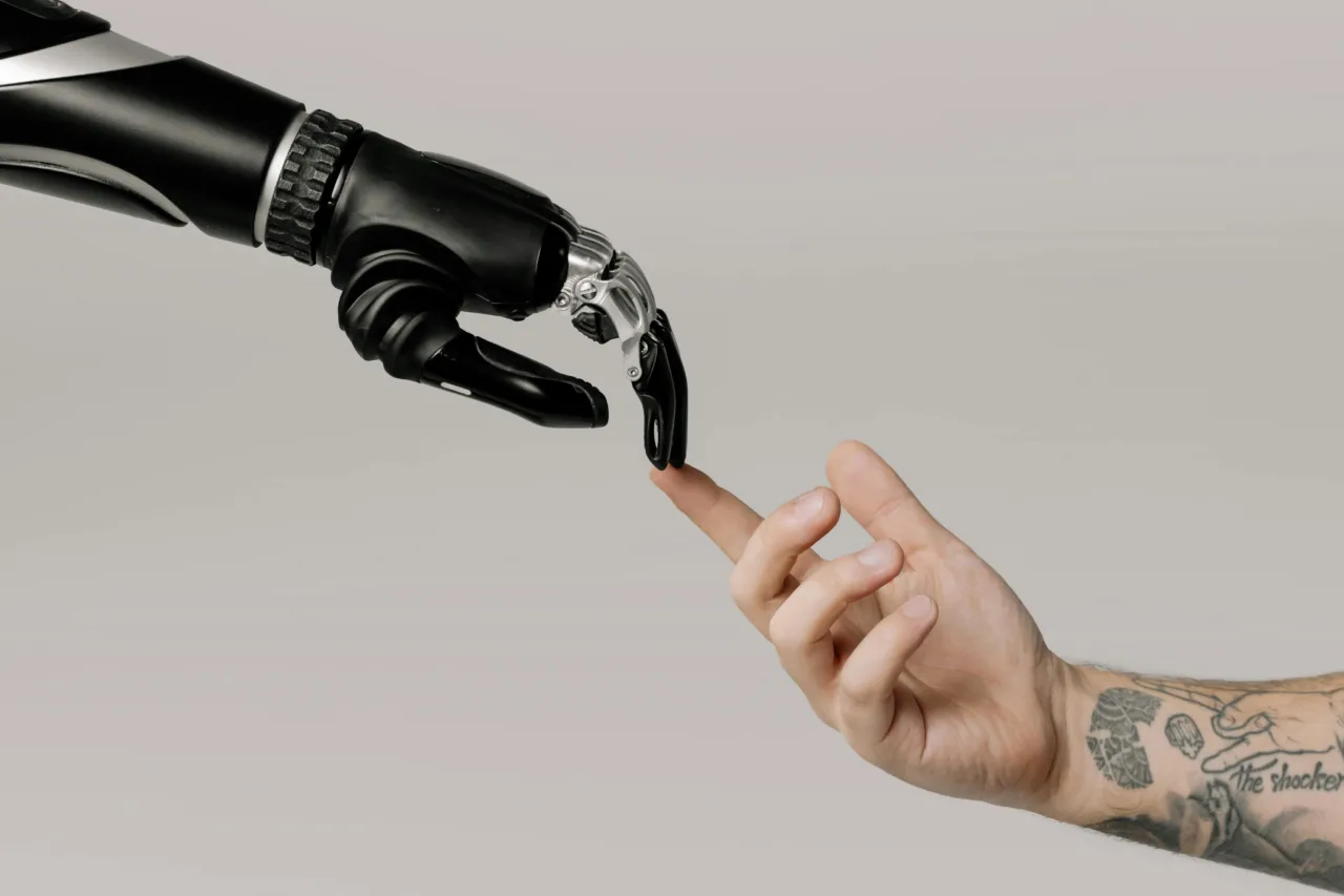 Robot hand touching a human hand's index finger