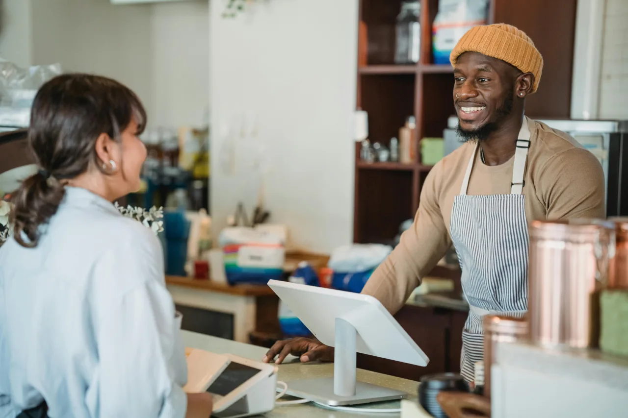Shop owner at checkout with customer