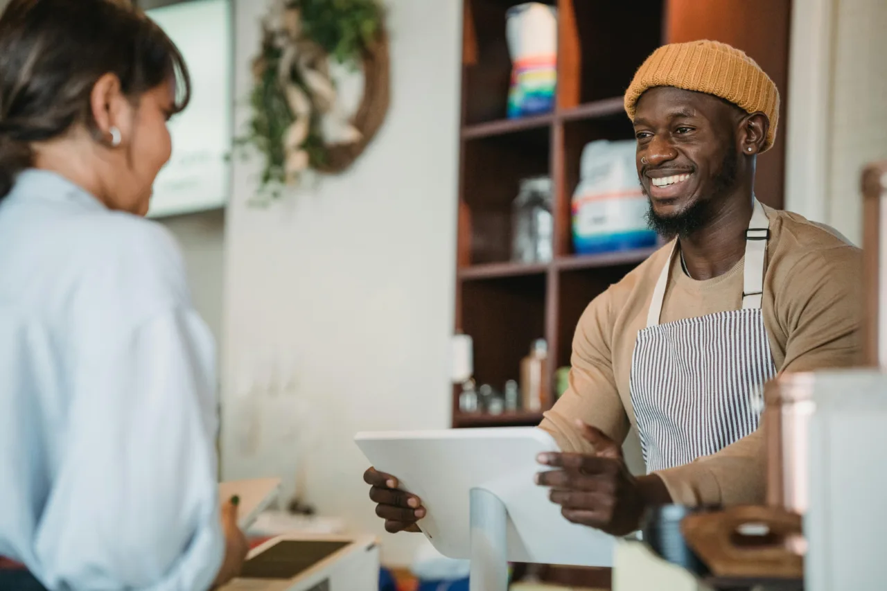 Small business owner at checkout with customer