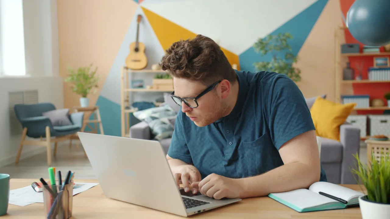 Adult male looking closely at a laptop